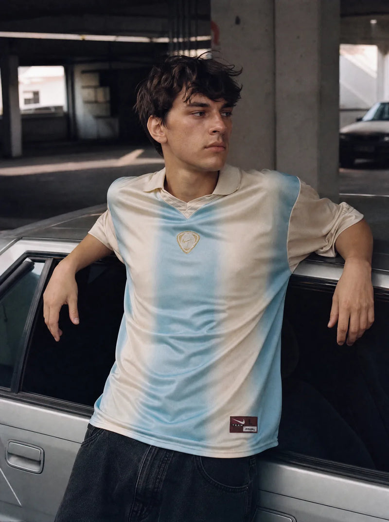 Cactus Jack × Total 90 — lichtblauw en zandkleurig shirt